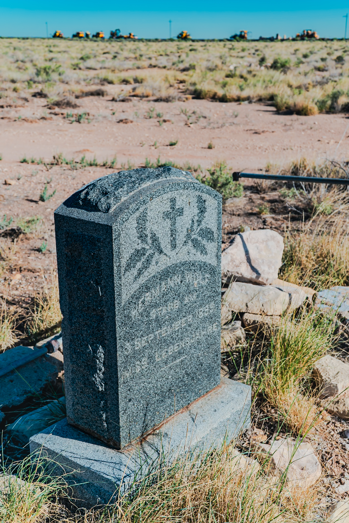 Hermann Wolf grave marker, Canyon Diablo, Arizona — German immigrant, trader with the Indians. His relatives crossed the Atlantic to erect this stone. The BNSF Seligman Subdivision production gang visible on the horizon was run by the photographer that day.