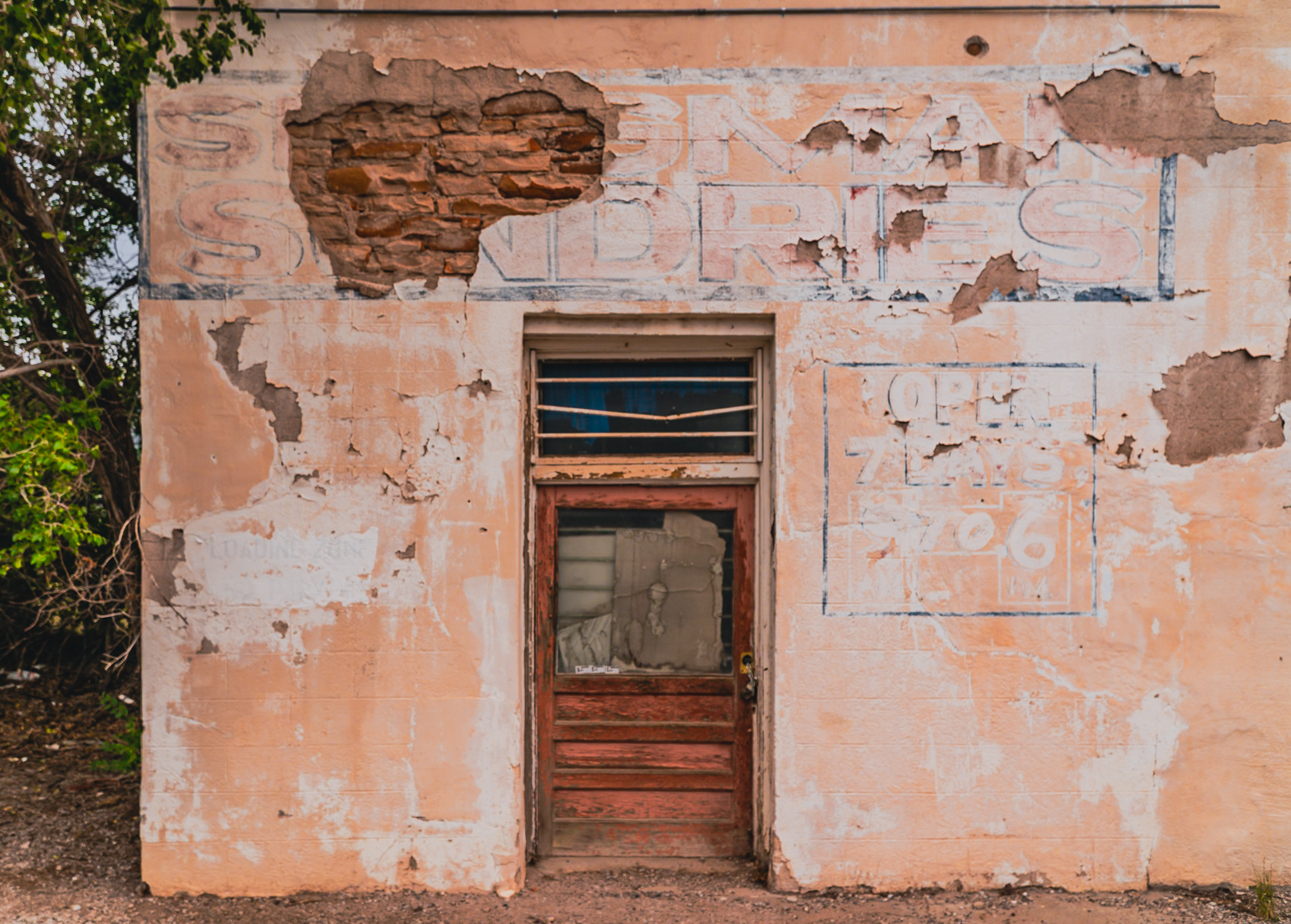 Abandoned Sundries store, Seligman Arizona — ghost signage through peeling stucco, Route 66